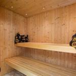 Sauna mit Holzwand, zwei Bänken und Sonnenblumenkissen.