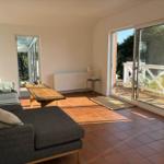 Wohnzimmer mit Sofa, Tisch und Terrassentür.