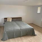 Schlafzimmer mit Bett, Holzboden und Fenster zur Außenseite.