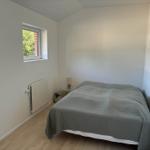 Schlafzimmer mit Bett, Fenster und Heizkörper.