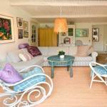 Wohnzimmer mit Sofa, Stühlen und Deckenventilator.