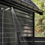 Außendusche an Holzhaus mit Wasserstrahl