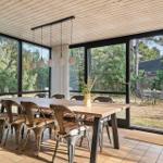 Esszimmer mit Holztisch, Metallstühlen und großem Fensterblick auf Garten.