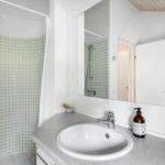 Badezimmer mit Dusche, Waschbecken und Spiegel