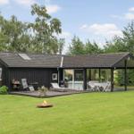 Ein Haus mit Terrasse, Garten und Feuerkorb. Moderne Architektur mit Glasfront.