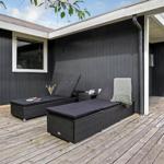 Terrasse mit zwei Liegestühlen und Holzboden vor schwarzem Haus.