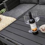Auf der Terrasse steht ein Tisch mit Wein, Gläsern und einer Schale Nüsse.