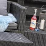 Außenbereich mit Sitzmöbeln, Flasche, Glas und Laterne.