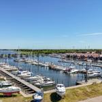 Hafen mit Booten und roten Häusern am Wasser.