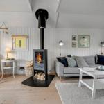 Wohnzimmer mit Kamin, Sofa und Holzboden