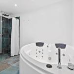 Bad mit Whirlpool und Dusche mit Glaswand.