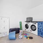 Wäscheschränke, Waschmaschine und Spielzeug in einem Raum.