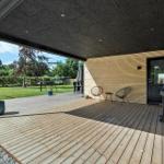 Terrasse mit Grill, Stühlen und Blick auf den Garten.
