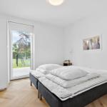 Schlafzimmer mit Bett, Tür zum Garten und Wandbild.