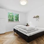 Schlafzimmer mit Bett, Fenster und Holzboden.