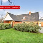 Rotes Backsteingebäude mit Dachgaube und Garten