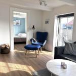 Wohnzimmer mit Sofa, Sessel und Kamin. Durchgang zur Schlafzimmer.