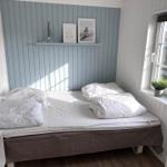 Schlafzimmer mit Bett, Fenster und Wanddekoration.