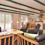 Wohn- und Essbereich mit Küchenzeile und großen Fenstern.