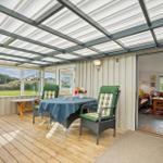 Terrasse mit Tisch, Stühlen und Blick auf Grünland.