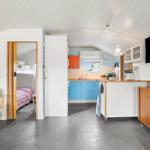 Küche mit blauen Schränken und Schlafbereich mit Hochbett.