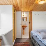 Schlafzimmer mit Bett, Kleiderschrank und angrenzender Dusche.