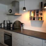 Küche mit Arbeitsplatte, Herd, Dunstabzug und Schrank