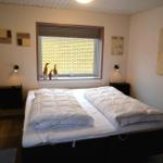 Schlafzimmer mit Doppelbett, Fenster und Wanddekoration.