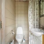 Badezimmer mit Toilette, Waschbecken und Duschvorhang.