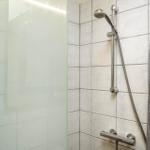 Dusche mit Glaswand und Handbrause an Wand montiert