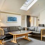 Wohnzimmer mit grauen Sofas, Holztisch und Dachfenster.
