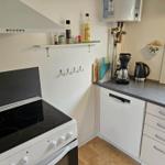 Küche mit Kochfeld, Spüle, Kaffeemaschine und Wasserkocher.