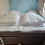 Schlafzimmer mit Bett, weißen Bettwäsche und Fenster