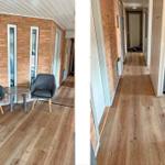 Flur mit Holzfußboden und Backsteinwand. Links Sitzbereich mit zwei Stühlen und Tisch.