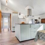 Küche mit Arbeitsplatte, Kühlschrank und Dunstabzug.