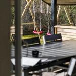 Außenbereich mit Tisch, Stühlen und Schaukel