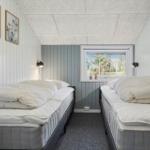 Zwei Betten in einem Raum mit Fenster und Wandbildern.