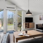 Wohnzimmer mit Sofa, Couchtisch und TV. Große Glastüren führen auf die Terrasse.