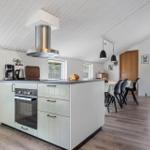 Küche mit Insel, Dunstabzugshaube und Essbereich mit Tisch und Stühlen.