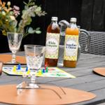 Außenbereich mit Tisch, Gläsern, Flaschen und Spielzeug.