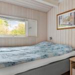 Schlafzimmer mit Bett, Fenster und Bild an der Wand.