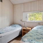 Zwei Einzelbetten mit blauen Bettwäschen und einem Nachttisch zwischen ihnen.