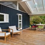 Terrasse mit Holzdielen, Sitzgelegenheiten und Blick in den Garten.