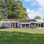 Moderne Ferienhaus mit Terrasse, Grill und Liegen im Grünen.