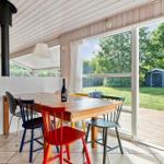 Essbereich mit Tisch, bunten Stühlen und Blick auf Garten.