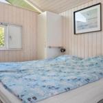 Schlafzimmer mit Bett, Fenster und Wandbild.