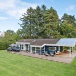 Moderne Villa mit großem Garten und Terrasse mit Liegen und Grill.