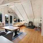 Wohnzimmer mit Holzboden, Kamin und großem Fensterblick