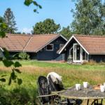 Haus mit Terrasse und Garten. Tisch mit Stühlen im Vordergrund.