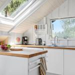 Küche mit Holz Arbeitsplatte, Fenster und Dachfenster.